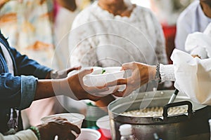 The hand of a beggar receives food from the donor: Donate food to hungry people