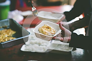 The hand of a beggar receives food from the donor: Donate food to hungry people