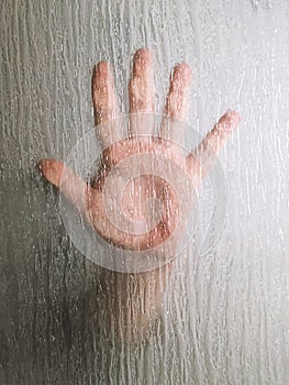 hand behind frosted glass window