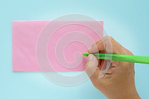 Hand being addressed on a pink envelope