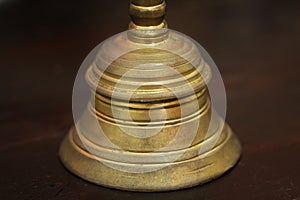 Hand bell on brown wood table