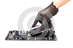 Hand in black glove installing memory module with heatsink in pc motherboard isolated on white background