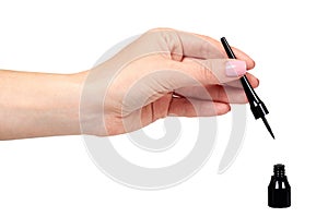 Hand with black liquid pencil, eye makeup brush