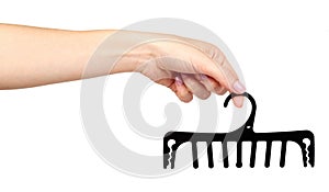 Hand with black plastic clothes hanger. Isolated background
