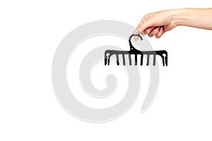 Hand with black plastic clothes hanger. Isolated background