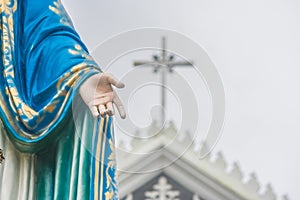 Hand of The Blessed Virgin Mary statue standing in front of The Roman Catholic Diocese.