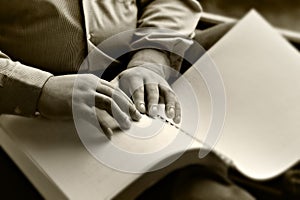 Hand of the blind reading a book Braille.