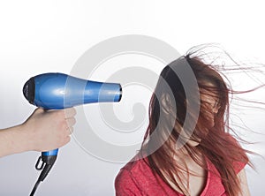 Hand with Blow Dyer Drying Long Hair of a Woman