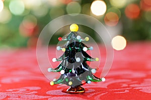 Hand Blown Christmas Tree Figure in Front of Christmassy Background