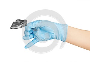 Hand in blue glove holding dental tool