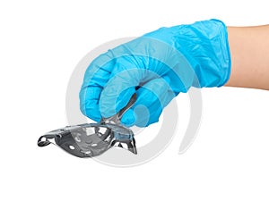 Hand in blue glove holding a metal impression tray for prosthodonticson on white background isolated