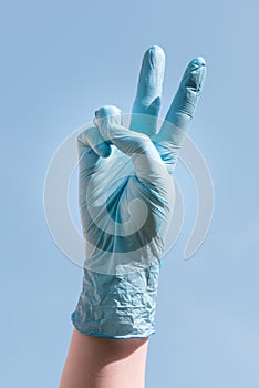 Hand with blue glove holding victory