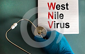 Hand in blue glove with stethoscope, white card with words `West Nile virus`. Medical epidemic concept