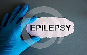 Hand in blue glove with white small paper. Concept word epilepsy