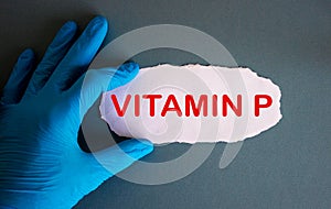 Hand in blue glove with white small paper. Concept word vitamin P