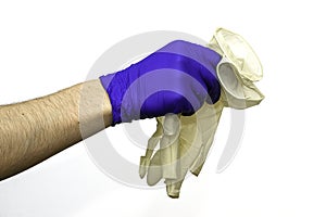 Hand in a blue protective surgical glove shivers white gloves on the white background