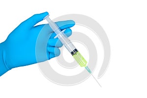 Hand in blue rubber glove holds syringe.