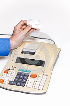 Hand removes check from printing calculator on white background