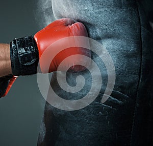 Hand of boxer and punching bag over black