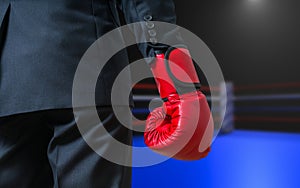 Hand of boxing businessman with red glove in box ring
