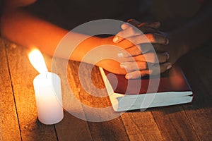 Hand boy praying In the room and lit candles to light , Hands folded in prayer concept for faith, spirituality and religion