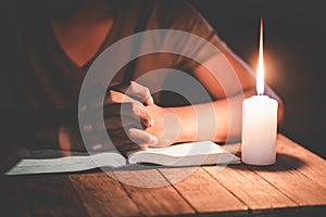 Hand boy praying In the room and lit candles to light , Hands folded in prayer concept for faith, spirituality and religion