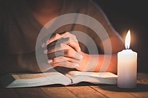 Hand boy praying In the room and lit candles to light , Hands folded in prayer concept for faith, spirituality and religion