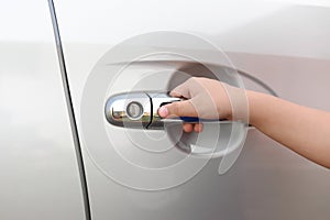 Hand boy pushing button of car handle