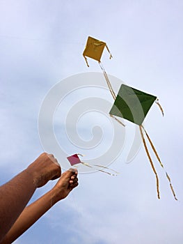 Hand of a boy raises a kite in a sky