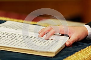 Hand of boy reading the Jewish Torah at Bar Mitzvah 01 august 2015