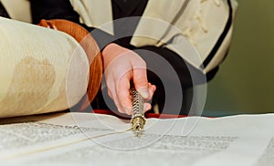 Hand of boy reading the Jewish Torah at Bar Mitzvah