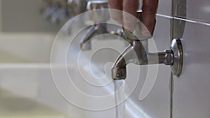 Hand of a boy who opens the tap