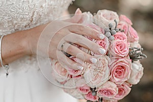 Hand of the bride with a ring holds a wedding bouquet. Wedding decorations.  The bride`s bouquet