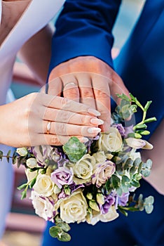 Hand of the bride with a ring holds a wedding bouquet. Wedding decorations. Close-up. The bride`s bouquet