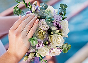 Hand of the bride with a ring holds a wedding bouquet. Wedding decorations. Close-up. The bride`s bouquet