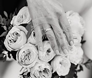 Hand of the bride with a ring holds a wedding bouquet. Wedding decorations. Close-up. The bride`s bouquet