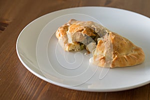 Hand broken pasty on a white plate