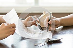 Hand of broker showing to client where to sign signature contract