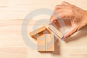 Hand building house real estate with wooden blocks