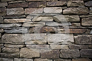 Hand built dry stone wall with different sized stones. Detail and texture.