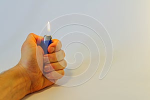 Hand burning a lighter on white background