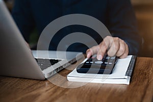 Hand busineaaman doing finances and calculate on desk about cost at office