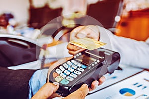 Hand of business man customer paying with NFC technology contactless credit card