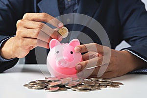 Hand of Business man holding coin put in piggy bank with money stack growing growth saving money, Concept invesment for financial