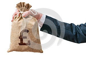 Hand of business man holds bag full of money with British pound photo