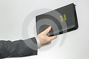 hand of a business man holds a bible. religion and christianity