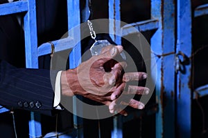 Hand of business man in jail with