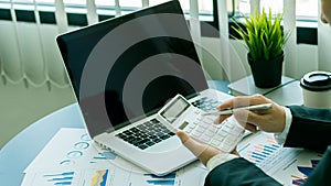 Hand of a business man using a calculator to check financial accounts, check expenditures and company