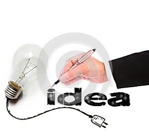 Hand of business man writing idea with light bulb beside