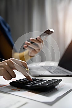 Hand business woman doing finances and calculate on desk about cost at office